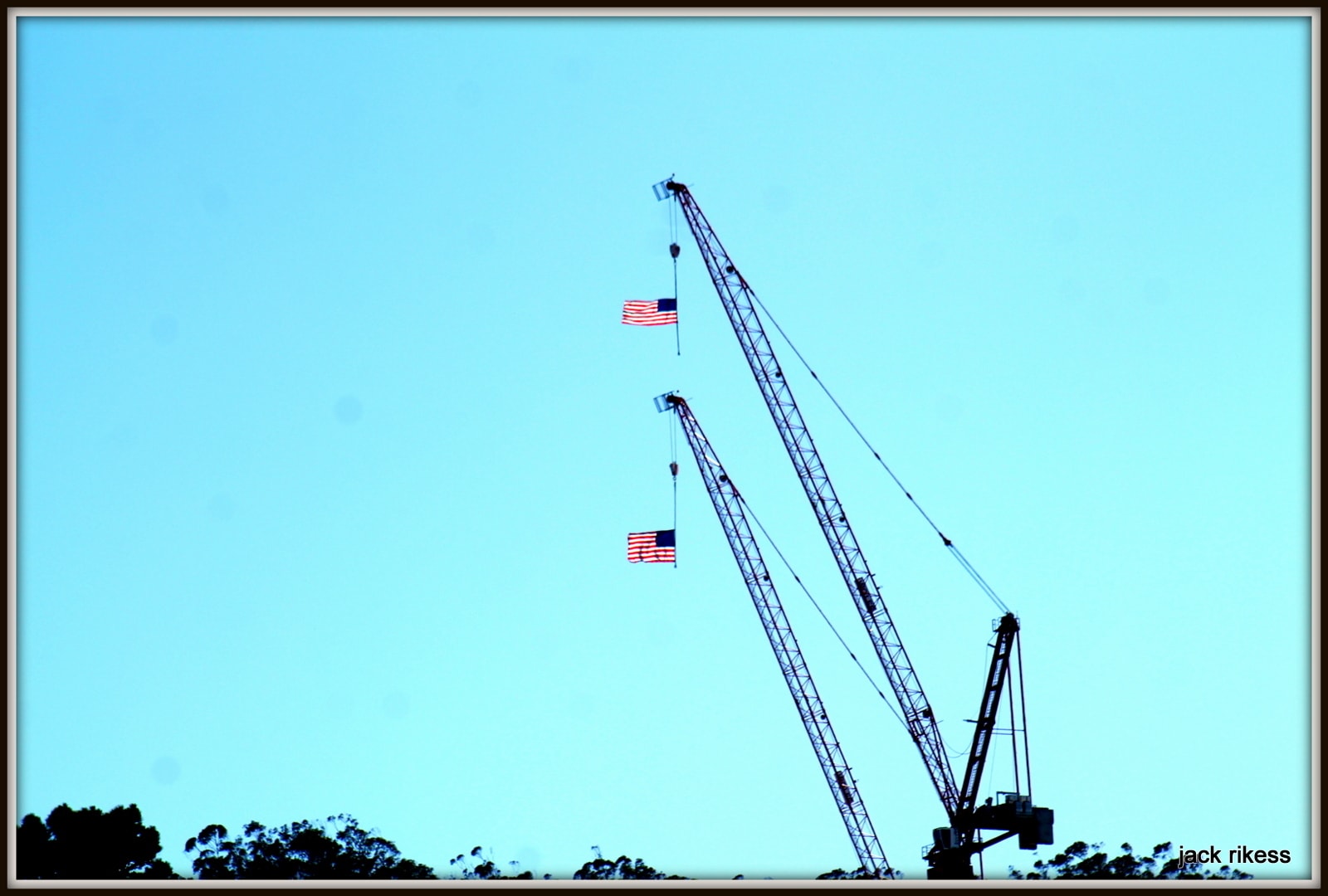 My Neighborhood — construction cranes with American flags against blue sky