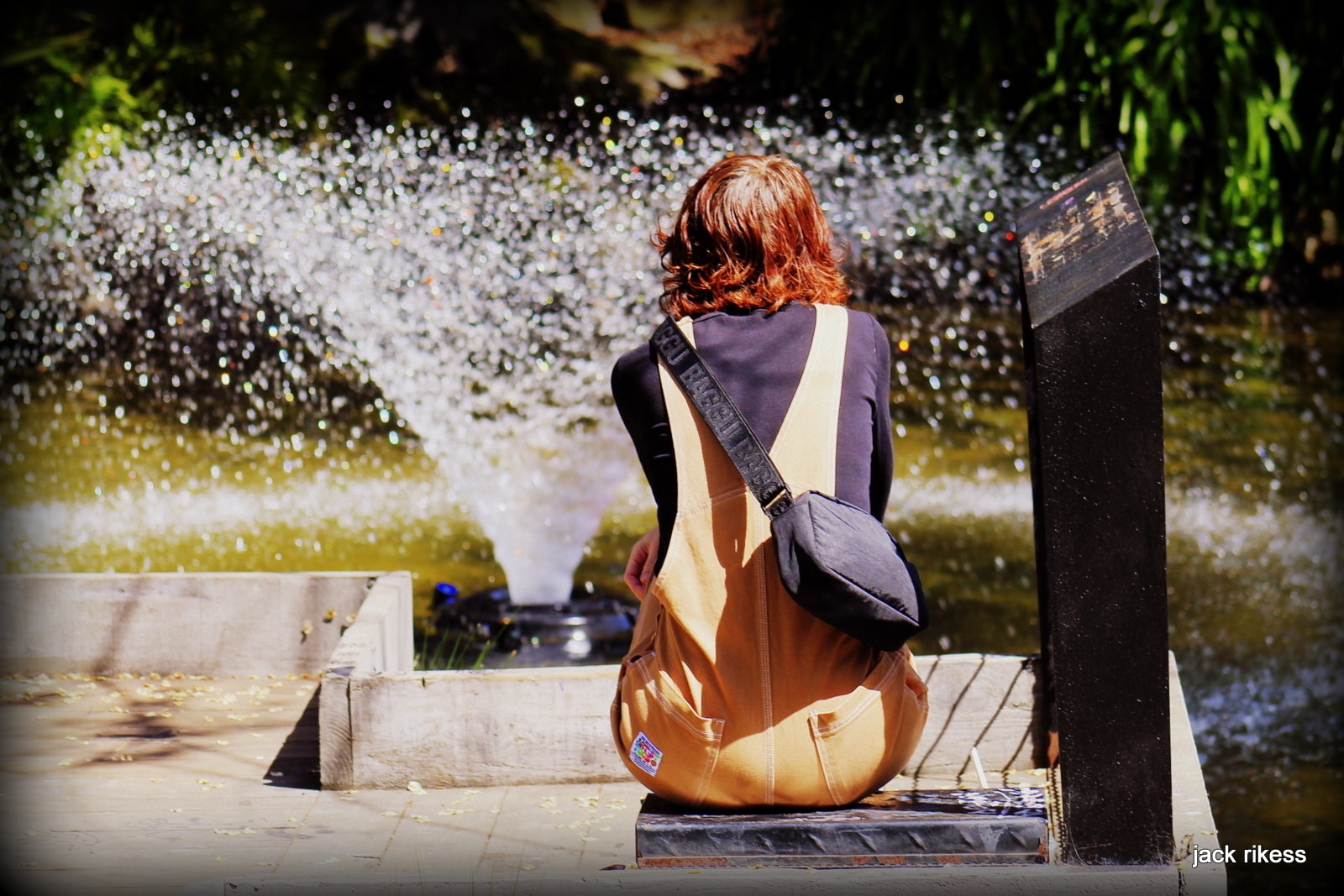 People — woman with red hair sitting by a fountain